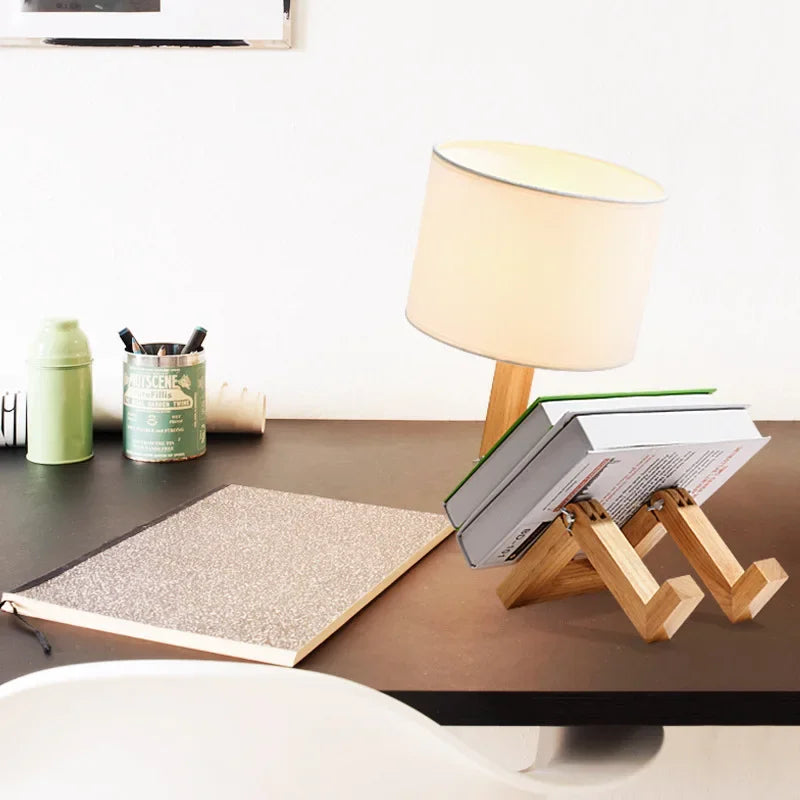 Illuminate your space with our Adjusted Robot Shape Table Lamp! This unique E27 lamp features a wooden and fabric design, perfect for bedrooms or study rooms. Its foldable structure offers versatility for any setting. Enhance your decor today!